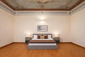 a bedroom with a bed and two tables with lamps at Open Sicily Quattro Canti Apartments in Palermo
