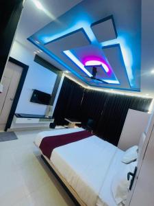 a bedroom with a large bed with a blue lighting at Hotel Kunj Bihari in Lucknow
