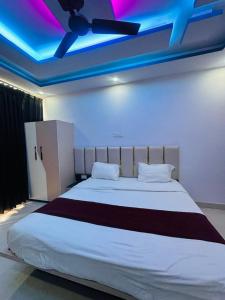 a bedroom with a large white bed with a ceiling at Hotel Kunj Bihari in Lucknow