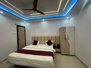 a bedroom with a bed with a blue light on the ceiling at Hotel Kunj Bihari in Lucknow +2 photos