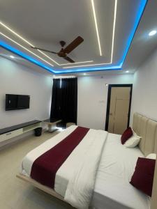 a bedroom with a bed and a ceiling with blue lights at Hotel Kunj Bihari in Lucknow