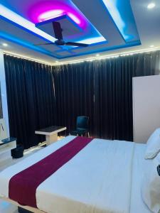 a bedroom with a large bed and a purple ceiling at Hotel Kunj Bihari in Lucknow