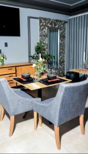 a dining room with a table and chairs and a mirror at Masana Hotels in Polokwane