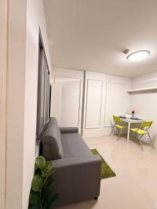 a living room with a couch and a table at Best Value Condo Lumpini Rajamangala in Sathani Khlong Tan