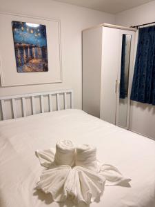 a white bed with a dress on it at Best Value Condo Lumpini Rajamangala in Sathani Khlong Tan +3 photos
