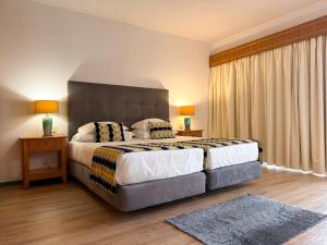 a bedroom with a large bed with two pillows at Luna Hotel da Oura in Albufeira