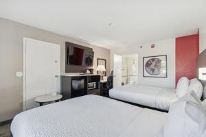 a hotel room with two beds and a flat screen tv at Ramada by Wyndham Temple Terrace/Tampa North in Tampa