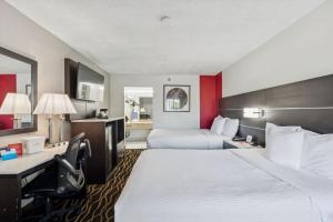 a hotel room with two beds and a desk at Ramada by Wyndham Temple Terrace/Tampa North in Tampa +43 photos