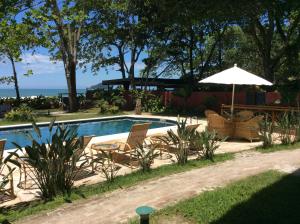 a swimming pool with chairs and an umbrella at Paradiso Al Mare in Camburi
