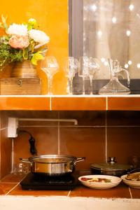 a kitchen counter with glasses and a pot on a stove at First Love Room in Thưy Ðầm +23 photos