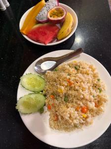 two plates of food with rice and fruit on a table at Vang Vieng Ruby Villa Hotel in Vang Vieng