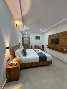 a bedroom with a large bed and a television at HOTEL FORTUNER Inn in Bangalore