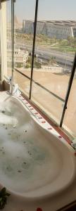 a bath tub in front of a window with a view at Giza Pyramids& GYM View in Cairo