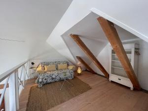 a living room with a couch in a attic at Wildernest Bornholm - Hjorten in Neksø