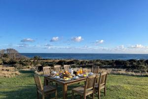 a table with food on it with the ocean in the background at Wildernest Bornholm - Hjorten in Neksø