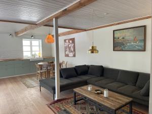 a living room with a couch and a table at Wildernest Bornholm - Hjorten in Neksø