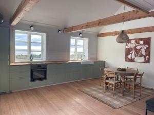 a kitchen with a table and a dining room at Wildernest Bornholm - Hjorten in Neksø