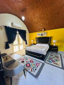 a bedroom with a bed and a yellow wall at Abu simbel Nubian Guest House in Abu Simbel +68 photos