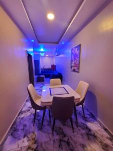 a dining room with a table and chairs and a bed at Romeo Apartment in Ipaja