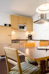 a kitchen with a table and chairs and a microwave at Ferienwohnung Abraham in Nauders