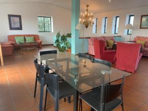 a dining room with a glass table and chairs at Cortijo Majada de las Vacas in Santa Olalla del Cala