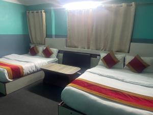a hotel room with two beds and a table at Parbat unique guest house in Kathmandu