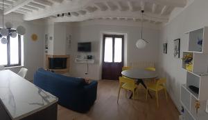 a living room with a table and a blue couch at La terrazza del Papa in Pienza