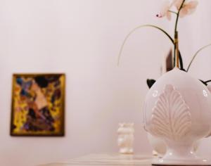 a white vase sitting on a table next to a painting at Le volte di Umberto Tramontana in Sogliano Cavour