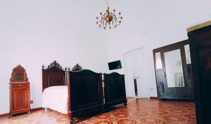 a bedroom with a bed and a chandelier at Le volte di Umberto Tramontana in Sogliano Cavour