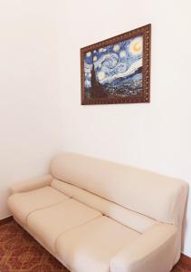 a white couch in a room with a painting on the wall at Le volte di Umberto Tramontana in Sogliano Cavour +26 photos