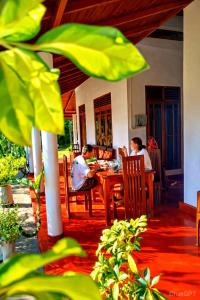 two people sitting at a table in a restaurant at Wilpattu Gagana guest in Nochchiyagama