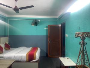 a bedroom with a bed and a room with a fan at Parbat unique guest house in Kathmandu