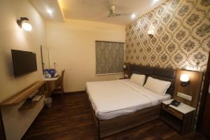 a hotel room with a bed and a television at Hotel P1 The Comfort Zone in Jalandhar