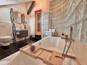 a bathroom with a tub and a sink and a toilet at Apartmány Bašta & Wellness in Sušice