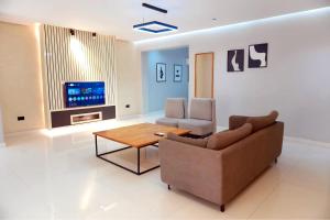 a living room with a couch and a table and a tv at 2020 Apartment Guzape in Chini