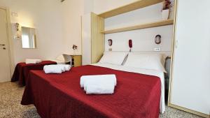 a bedroom with a large bed with a red blanket at Hotel Bel Air Frontemare in Rimini