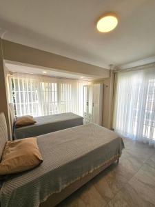 two beds in a bedroom with windows at Luxury 5BR Villa w Pool & Beach Access Ayvalık in Ayvalık +49 photos