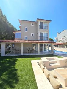 a large house with a lawn in front of it at Luxury 5BR Villa w Pool & Beach Access Ayvalık in Ayvalık