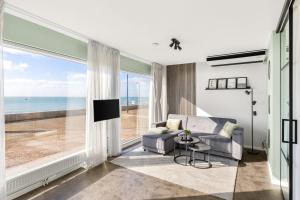 a living room with a couch and a view of the ocean at Horizon Suite at Sea in Vlissingen