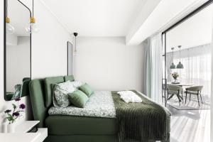 a bedroom with a green bed and a dining room at Horizon Suite at Sea in Vlissingen