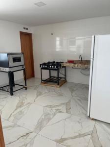 a kitchen with a counter and a refrigerator in it at Temporada Moto GP - 18km do autódromo de Goiania- acomoda 10 pessoas - Atlanta eventos in Goiânia