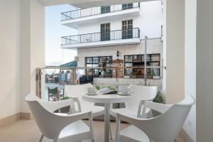 a white table and chairs in a room with a building at Hotel Cala Bona in Cala Bona