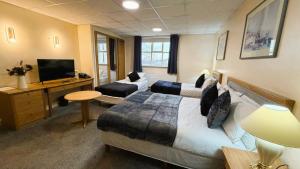 a hotel room with two beds and a flat screen tv at Throstles Nest Hotel in Liverpool