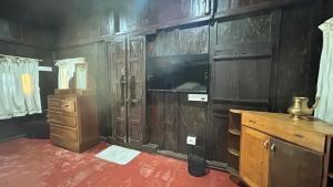 a room with wooden walls and a tv and a desk at Havmi Wellness Resort in Kumarakom