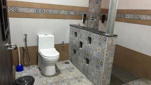 a bathroom with a white toilet in a room at Havmi Wellness Resort in Kumarakom