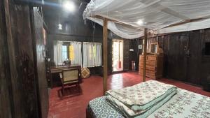a bedroom with a canopy bed and a desk at Havmi Wellness Resort in Kumarakom