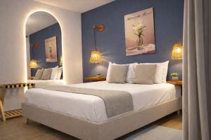 a bedroom with two beds with blue walls at Muguet House Granada in Cali