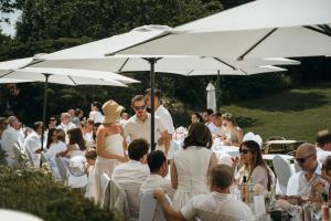 a group of people sitting under umbrellas at a wedding at Château de Looz in Borgloon +188 photos