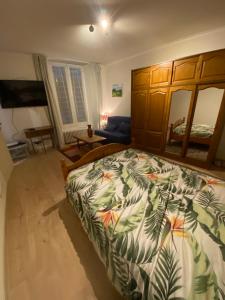 a bedroom with a large bed with a tropical bedspread at Appartement Kylie in Néris-les-Bains