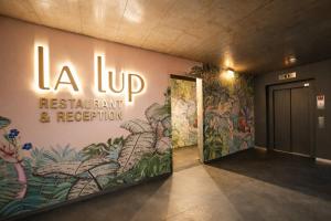 a wall with a sign that reads la up restaurant and reception at VISIONAPARTMENTS Wolframplatz - self check-in in Zurich